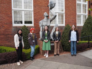 Students standing by statue 