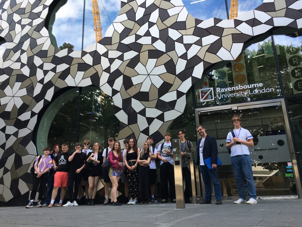 Group of students outside a large mosiac entrance