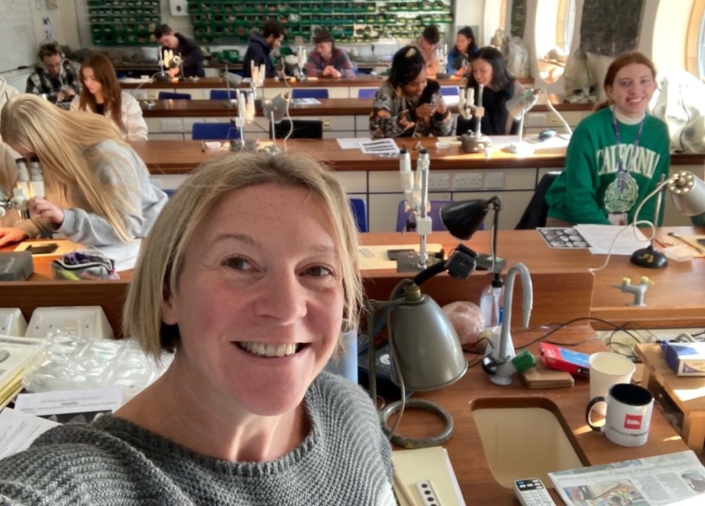 Smiling lecturer with students in the background