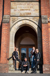 4 students on the steps of an old doorway