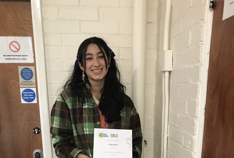 Student - Yvette smiling holding their certificate