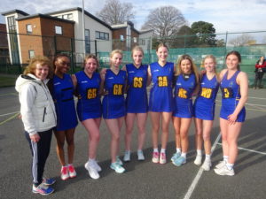 Group of smiing players in royal ble sports clothes with coach Michelle