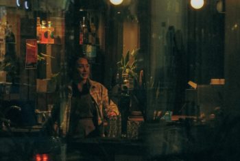 atmospheric urban image Light bulbs, person in a bar, bottles on a shelf